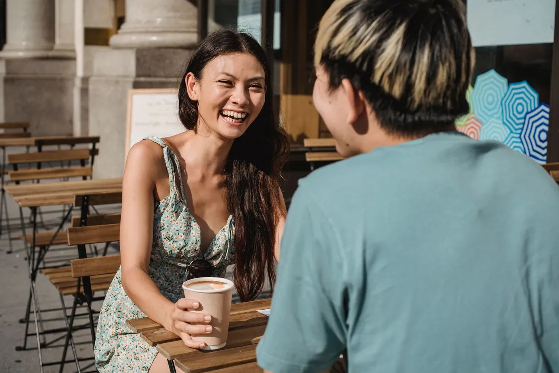屋外のカフェで友人同士が会話する様子